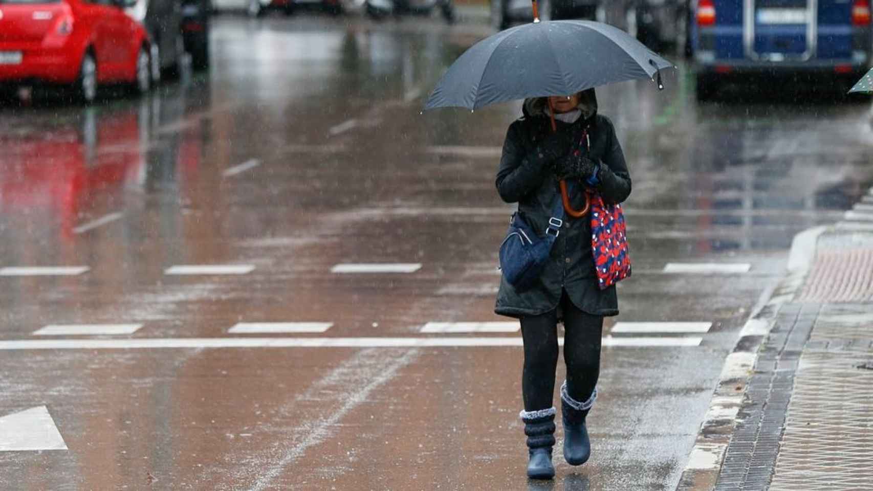Una mujer camina bajo la lluvia.