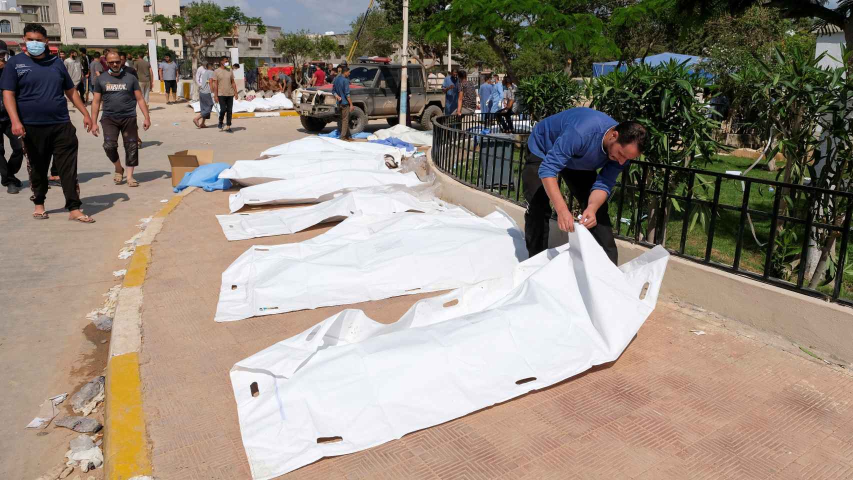Un hombre observa un cadáver dentro de una bolsa de plástico, el martes en Derna.