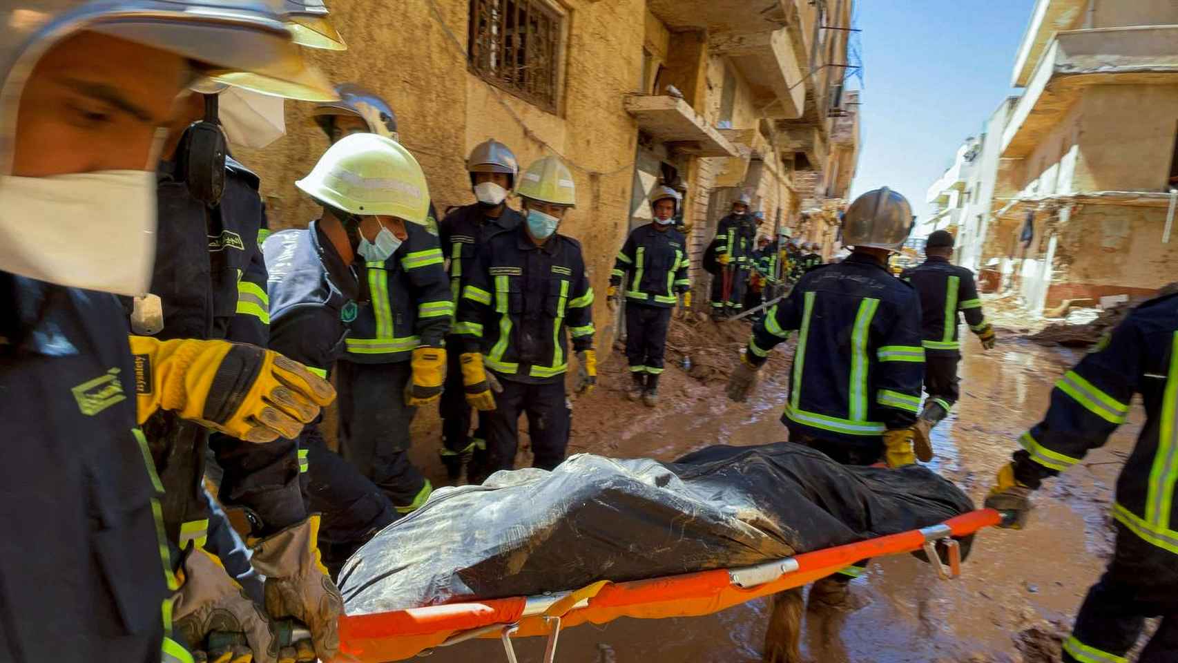 Rescatistas egipcios transportan un cadáver por las calles enfangadas del centro de Derna, el miércoles.