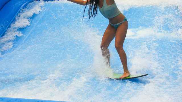 Imagen de archivo de una chica en una piscina de olas practicando surf.