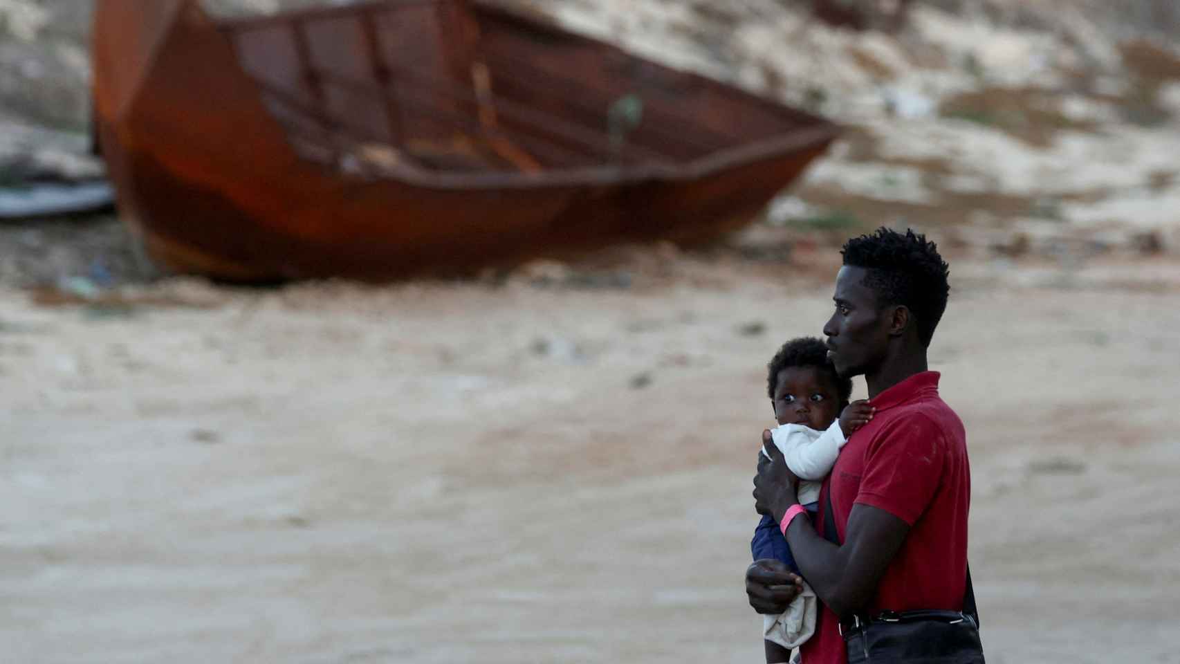 Un padre con su hijo en la costa de Lampedusa.