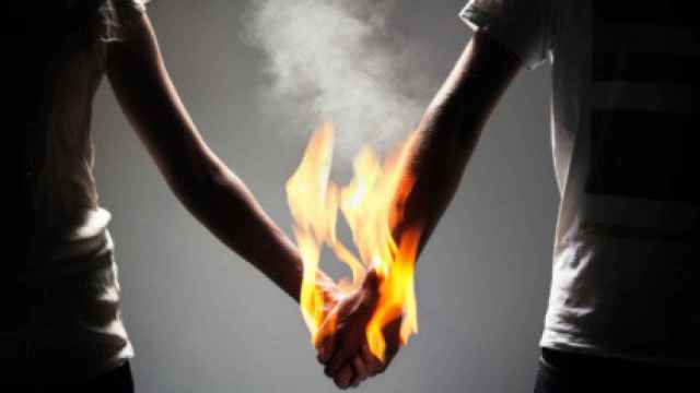 Imagen de una pareja cogida de la mano echando fuego.