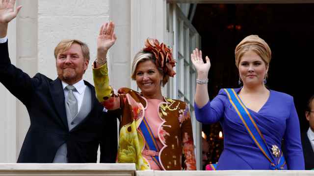 Los Reyes y la princesa Amalia saludan en el balcón de palacio.