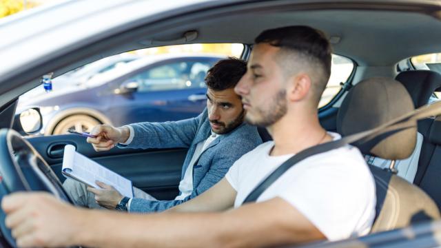 Un joven durante una clase de conducir con su profesor de la autoescuela.