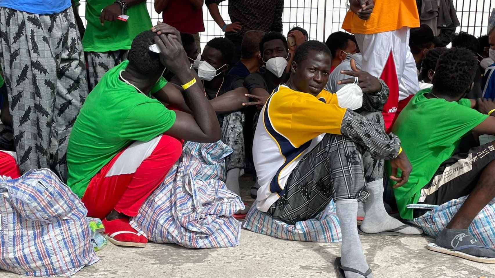 Migrantes en el puerto de Lampedusa este jueves esperan embarcar un ferry a Sicilia.