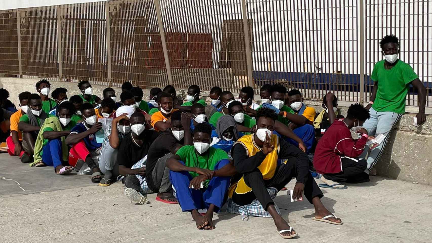 Migrantes este jueves en el puerto de Lampedusa esperando embarcar un ferry con destino a Sicilia.