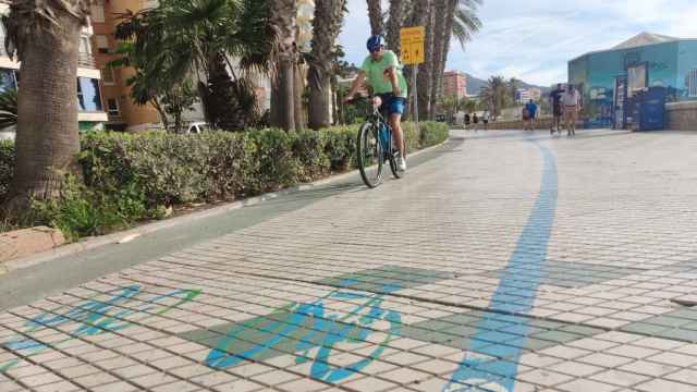 Una bicicleta circula por el carril bici pintado sobre el paseo marítimo Pablo Ruiz Picasso de Málaga.