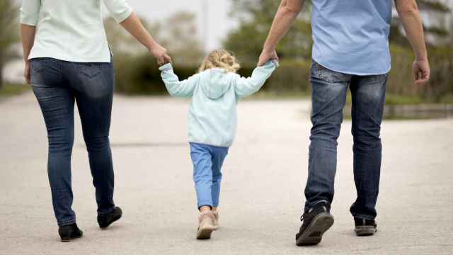 Una niña caminando con sus padres