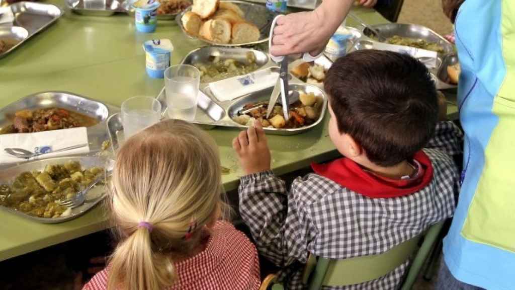 Unos niños comen en un comedor escolar.