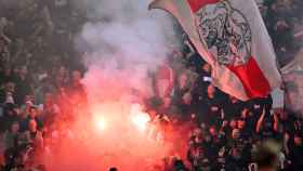 Los aficionados del Ajax lanzan bengalas al terreno de juego