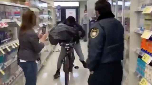 Imagen de un vídeo en el que un hombre roba artículos de una tienda ante la mirada del responsable de seguridad.