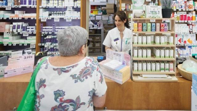 Imagen de archivo de una jubilada comprando en una farmacia.