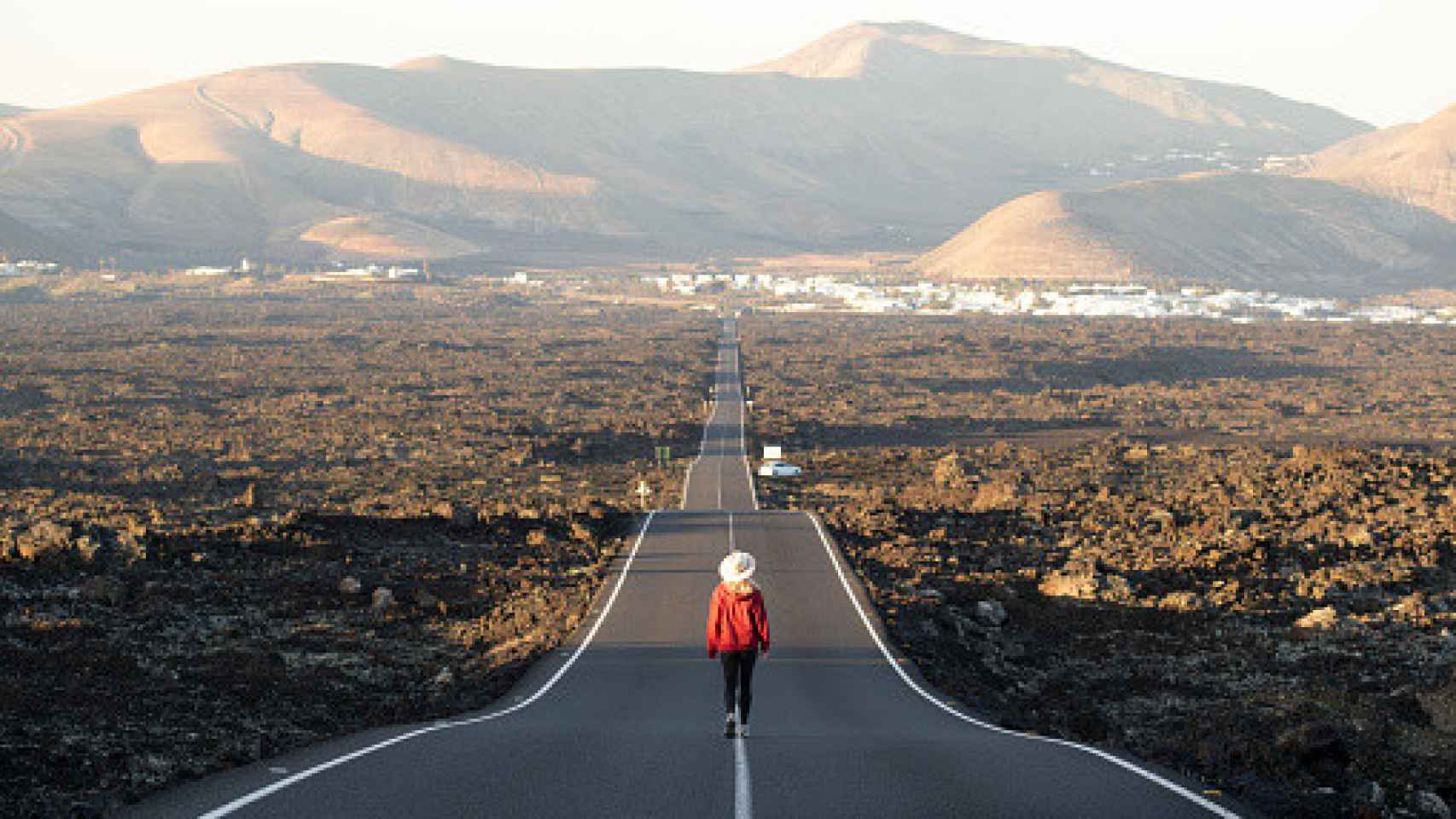 Imagen de un hombre caminando solo por la carretera.