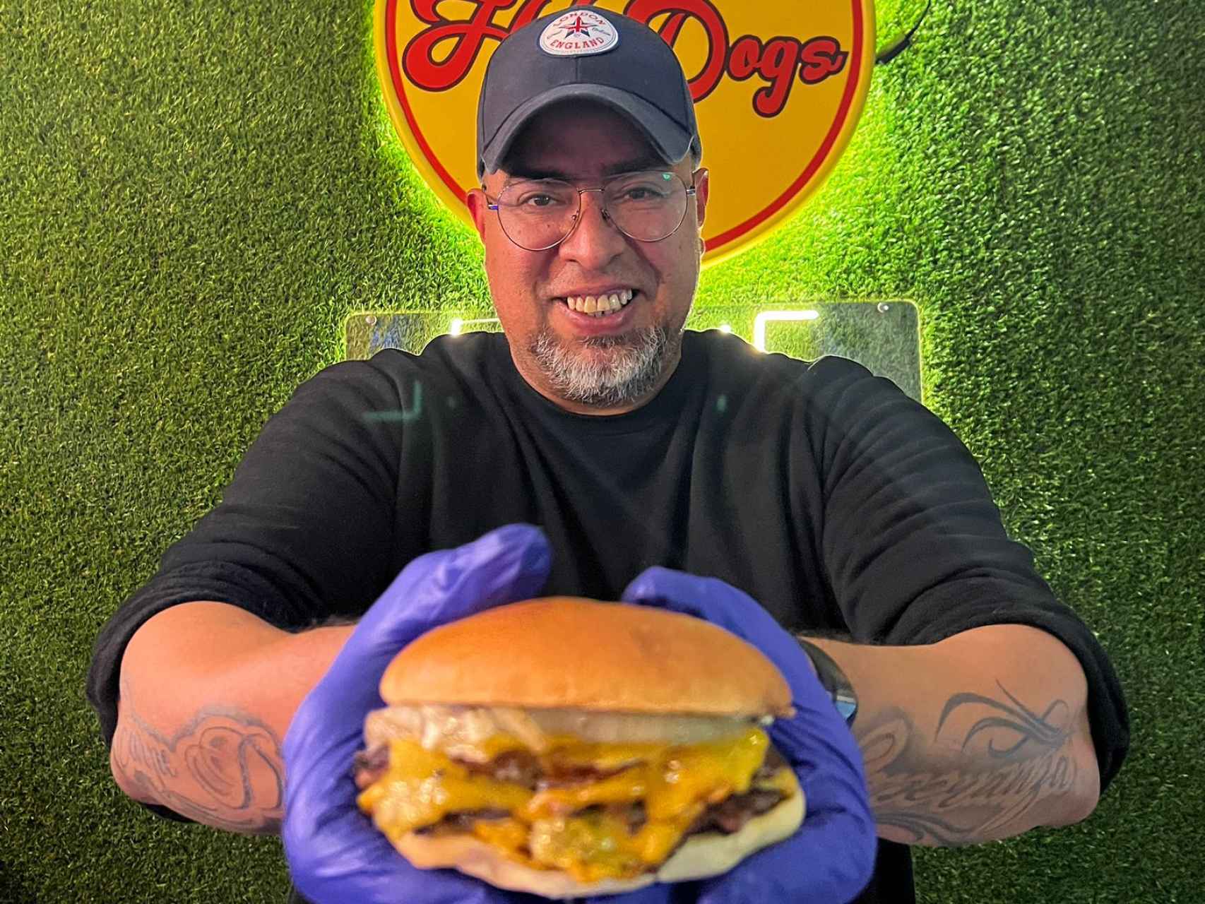 Joe Lastra, dueño de Hot Dogs Likes 1994, muestra una de sus hamburguesas.
