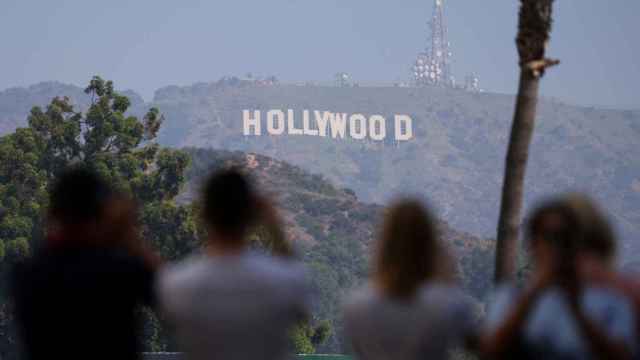 Un grupo de turistas fotografía el icónico cartel de Hollywood en California.