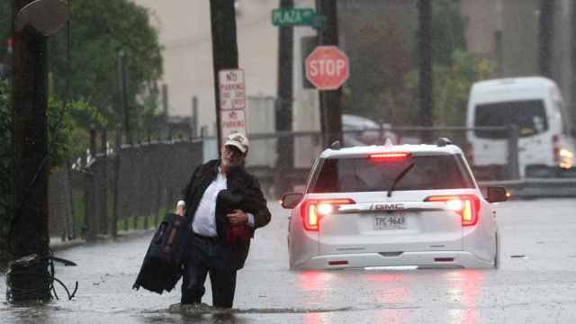 Un hombre lleva sus pertenencias mientras abandona su vehículo, el viernes en el condado de Westchester.
