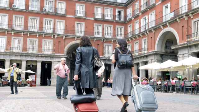 Dos turistas caminan por la Plaza Mayor de Madrid.
