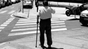 Un hombre mayor pasea apoyándose en un bastón en Madrid.