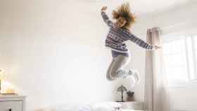 Imagen de archivo de una mujer saltando sobre la cama. Foto: iStock.