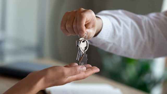 Imagen de un agente inmobiliario dando claves al cliente.