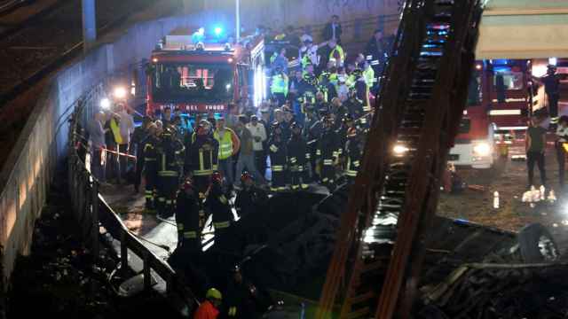 El personal de rescate asiste al lugar, después de que un autobús se estrellara en un paso elevado en Mestre, Italia.