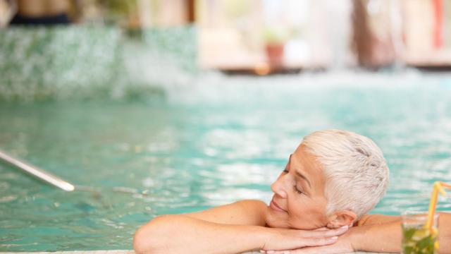 Una mujer disfruta de un baño en la piscina de un balneario.