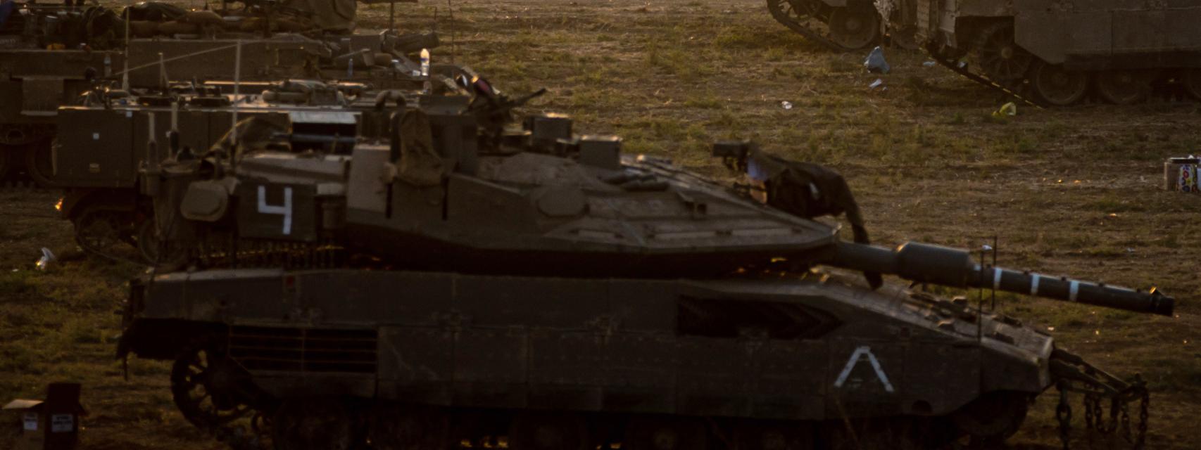 Un soldado israelí camina junto a varios tanques en los alrededores de la Franja de Gaza, en el sur de Israel.