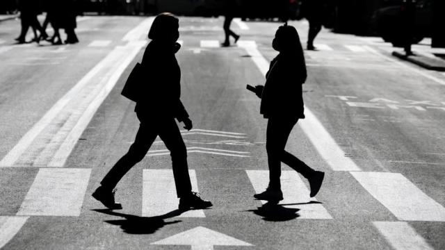 Dos personas se cruzan en una calle de la ciudad de Valencia.