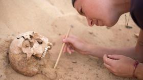 Arqueóloga limpiando una calavera en el yacimiento de San Marcial de Rubicón