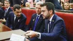 El presidente de Andalucía, Juanma Moreno (i), conversa con el de la Generalitat, Pere Aragonés (d), ante su homólogo de Galicia, Alfonso Rueda (c) durante la Comisión General de las Comunidades Autónomas que se celebra en el Senado, este jueves.