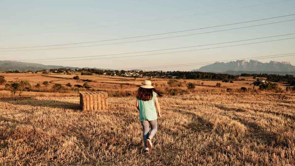 Una joven caminando en el campo.