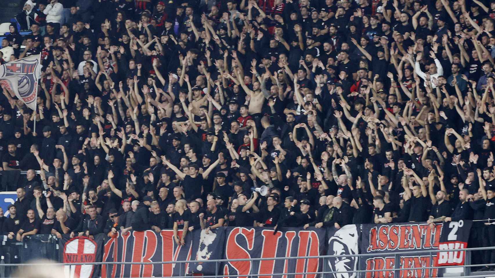 Aficionados del Milán realizan cánticos durante el partido.