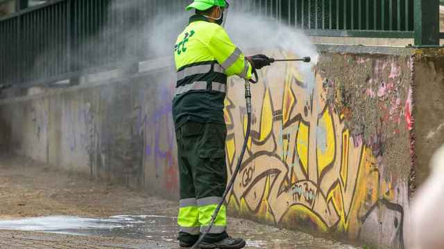 Un operario limpiando un grafiti.
