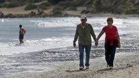 Personas paseando por la playa en un día cálido