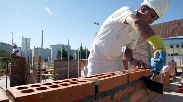 Un trabajador coloca unos ladrillos en una obra