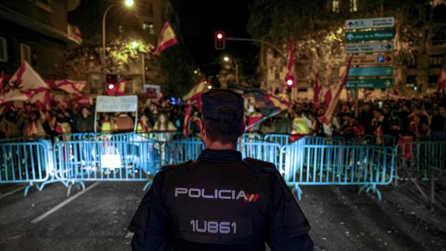 Un agente policial frente a asistentes a la concentración en contra de la amnistía celebrada este domingo en las inmediaciones de la sede del PSOE en Ferraz, Madrid.