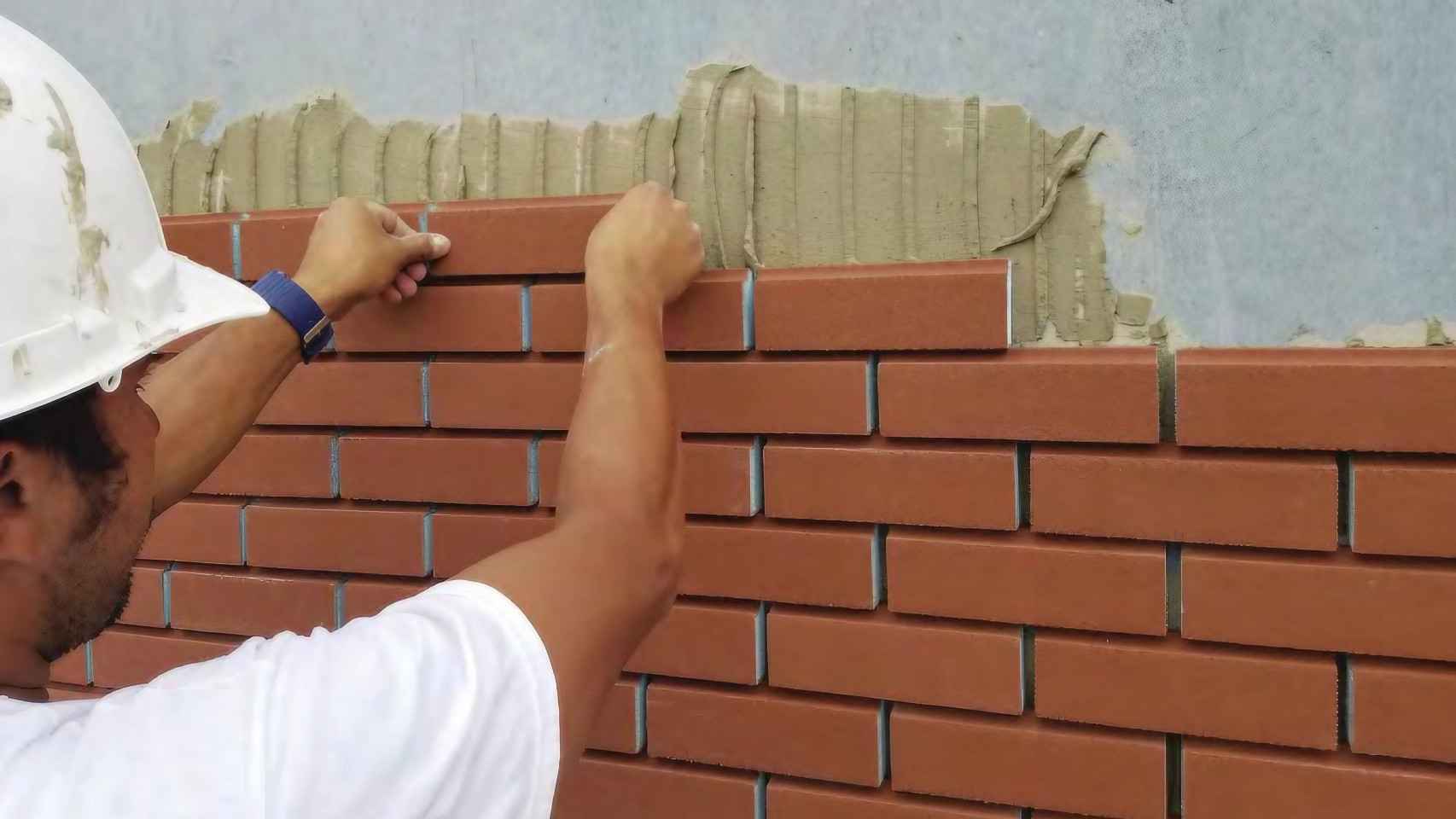 Una persona construyendo un muro con el ladrillo NewBrick.