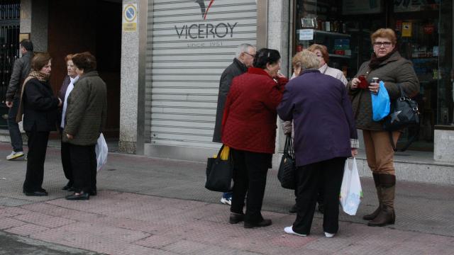 Dos grupos de personas hablando en la calle.