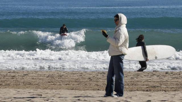 Unos surfistas en el agua en la Playa de la Malvarrosa de Valencia.