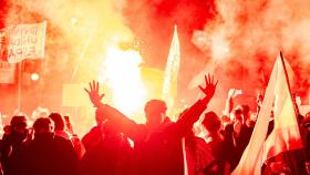 Decenas de manifestantes con banderas y botes de humo, durante una manifestación contra la amnistía.
