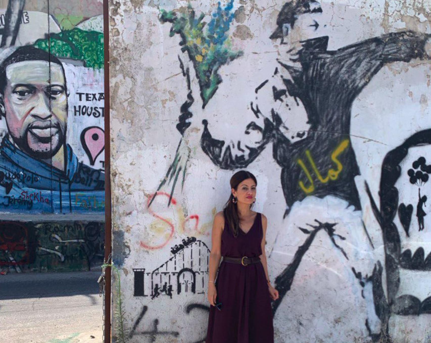 Sira Rego frente a un mural reivindicativo.