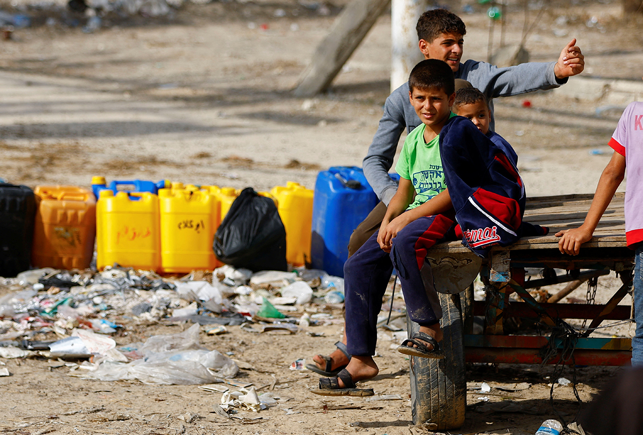 Los palestinos recogen agua, en medio de la falta de agua limpia y potable, mientras continúa el conflicto entre Israel y Hamas, en Rafah. Reuters