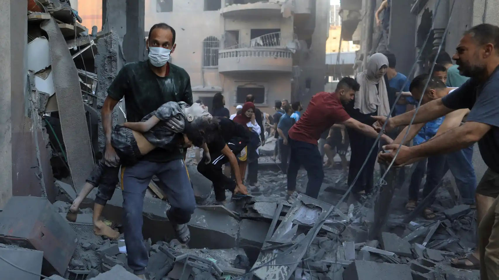 Un hombre traslada a un niño herido tras un bombardeo de Israel sobre la localidad de Jan Yunis. Reuters